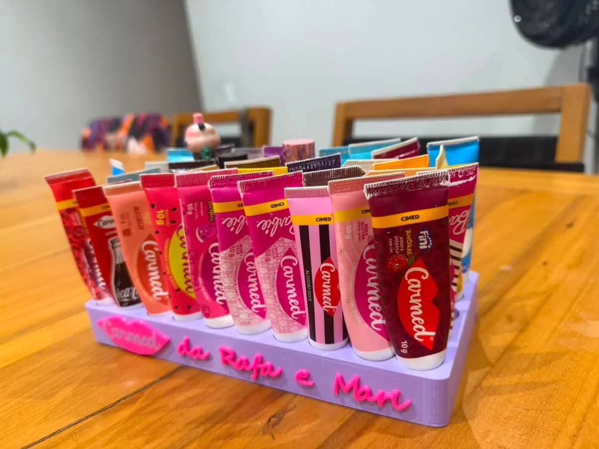 Foto enviada por cliente: porta carmed lilás personalizado com os nomes Rafa e Mari, cheio de Carmeds sobre uma mesa.